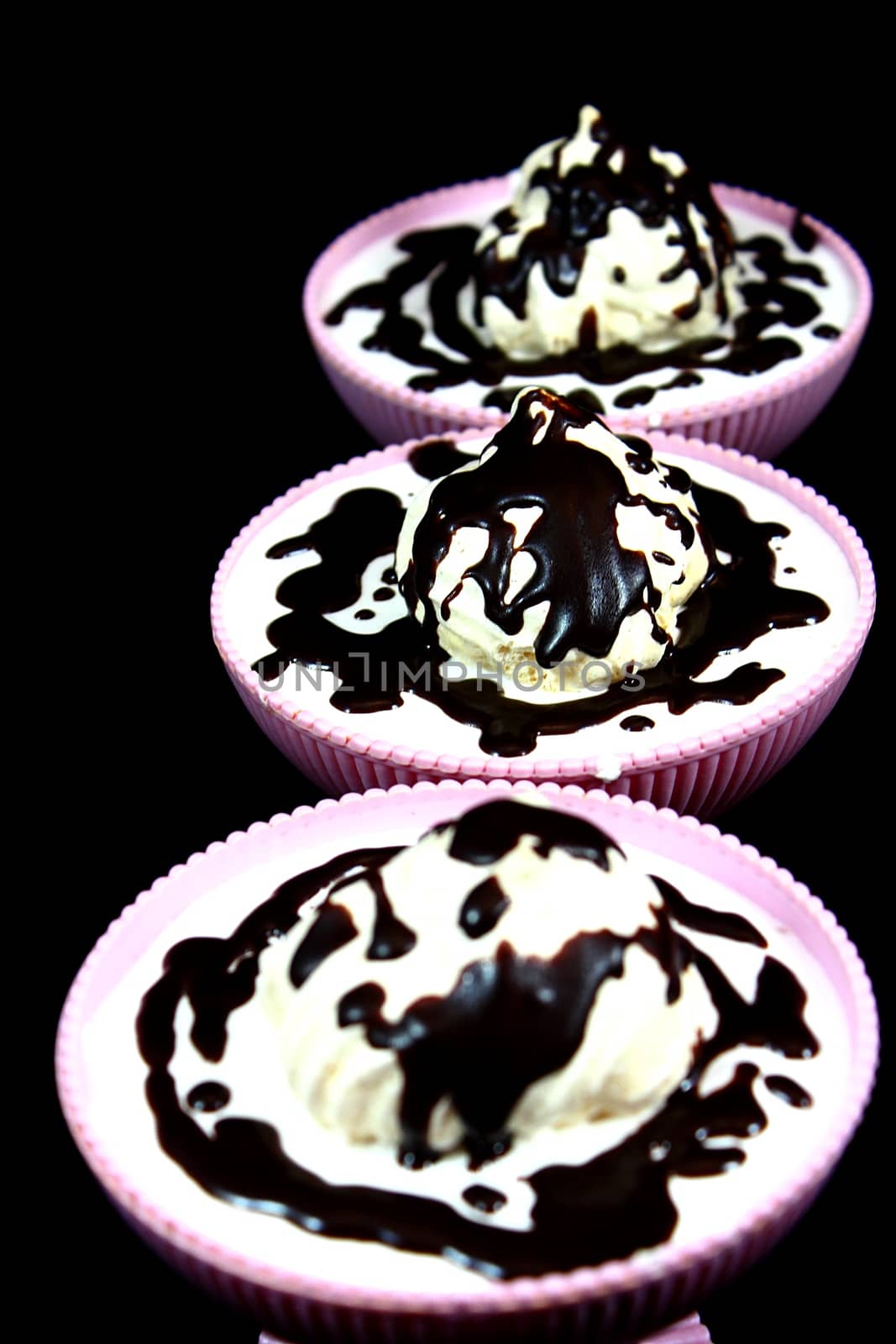 Dessert on a black background in three bowl of chocolate