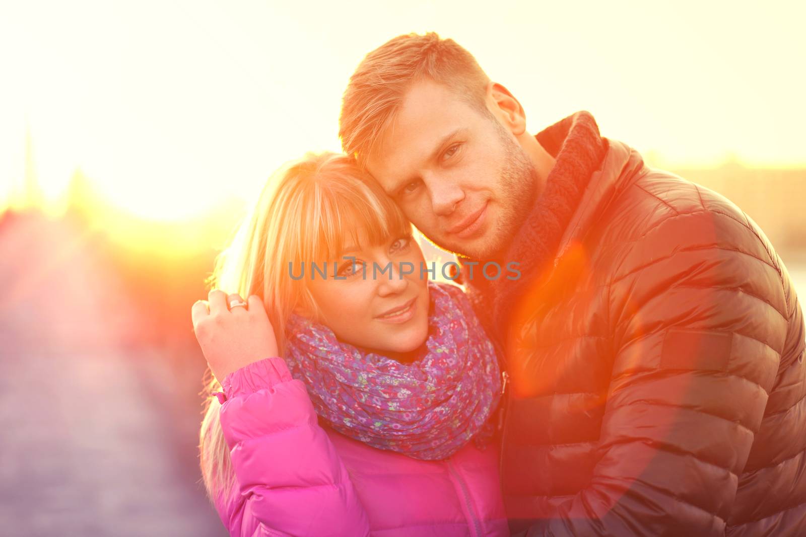Romantic young lovers couple in the beams of sunset
