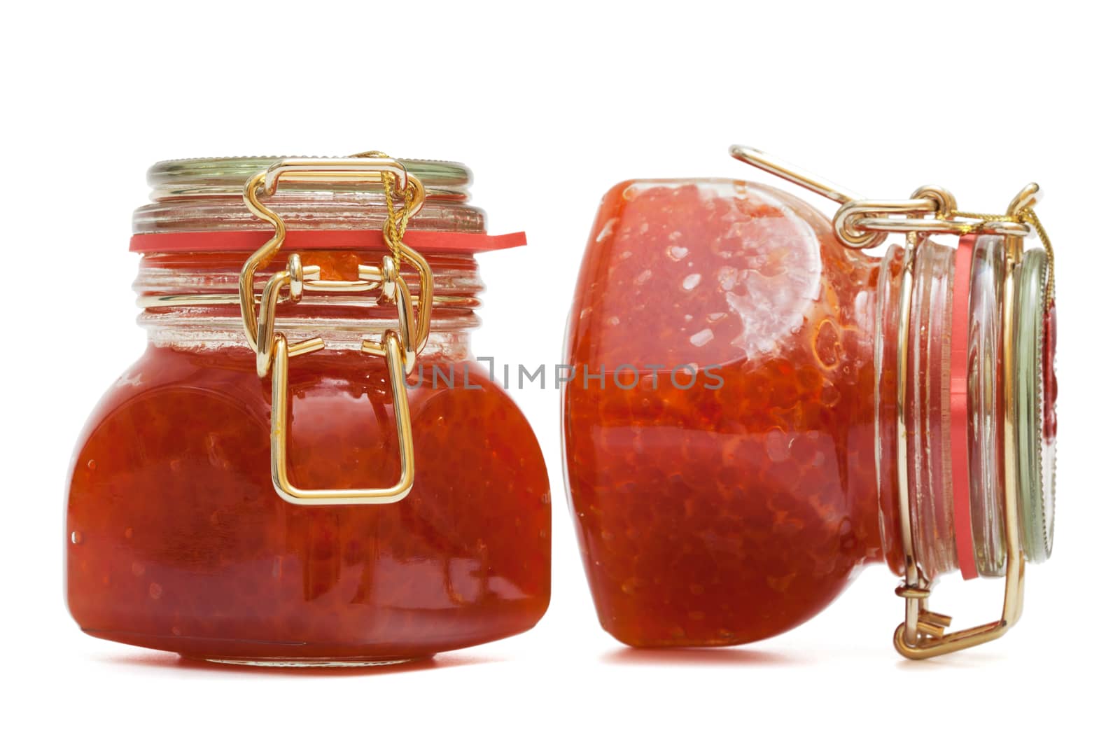 Red caviar in glass jar on a white background