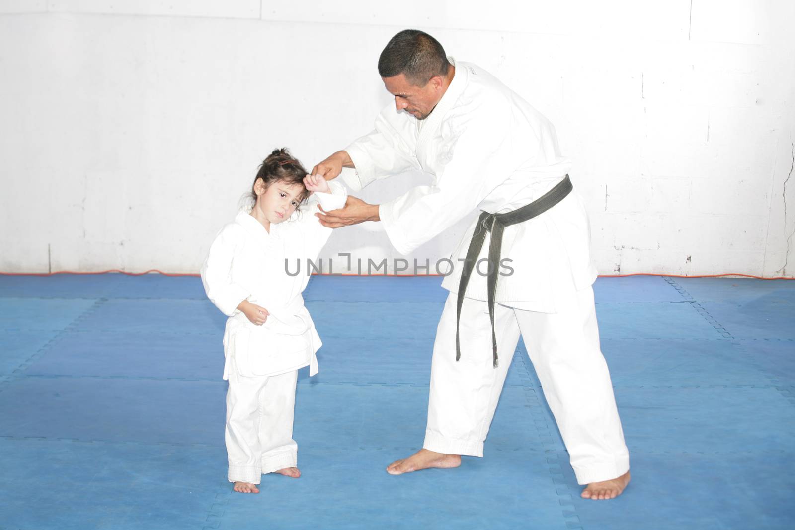 Black belt Karate teaching a little girl by dacasdo