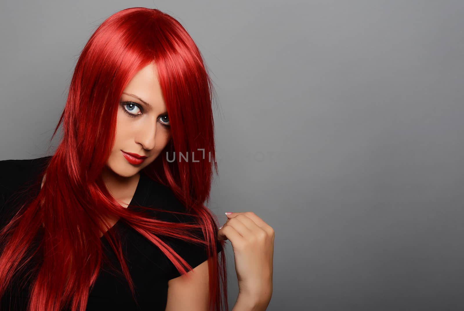 Beautiful red haired woman over gray background