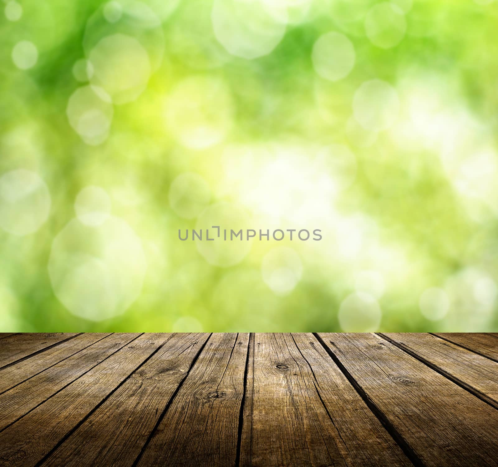 Empty wooden deck table with green spring background. Ready for product display montage.
