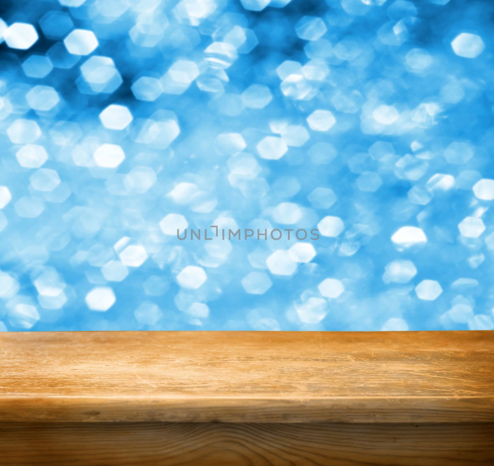 Empty wooden deck table with blue christmas background. Ready for product display montage.