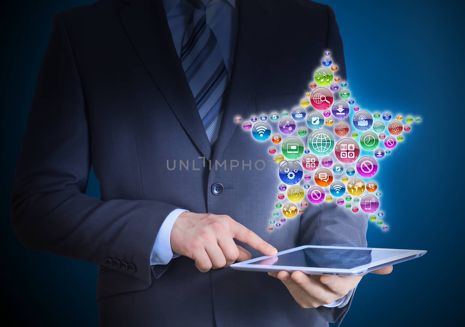 Businessman in a suit holding a tablet in his hands. Above the screen tablet application icons in the form of star