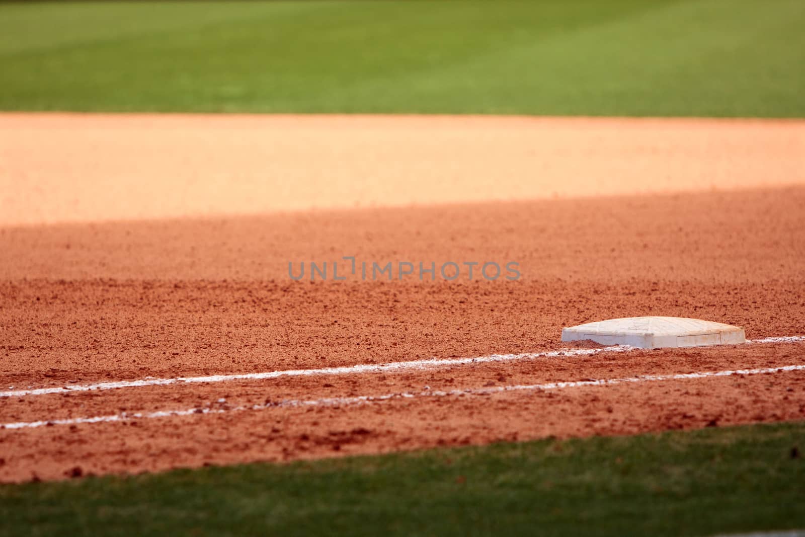 First base is featured in empty baseball field, showing infield dirt and outfield grass.