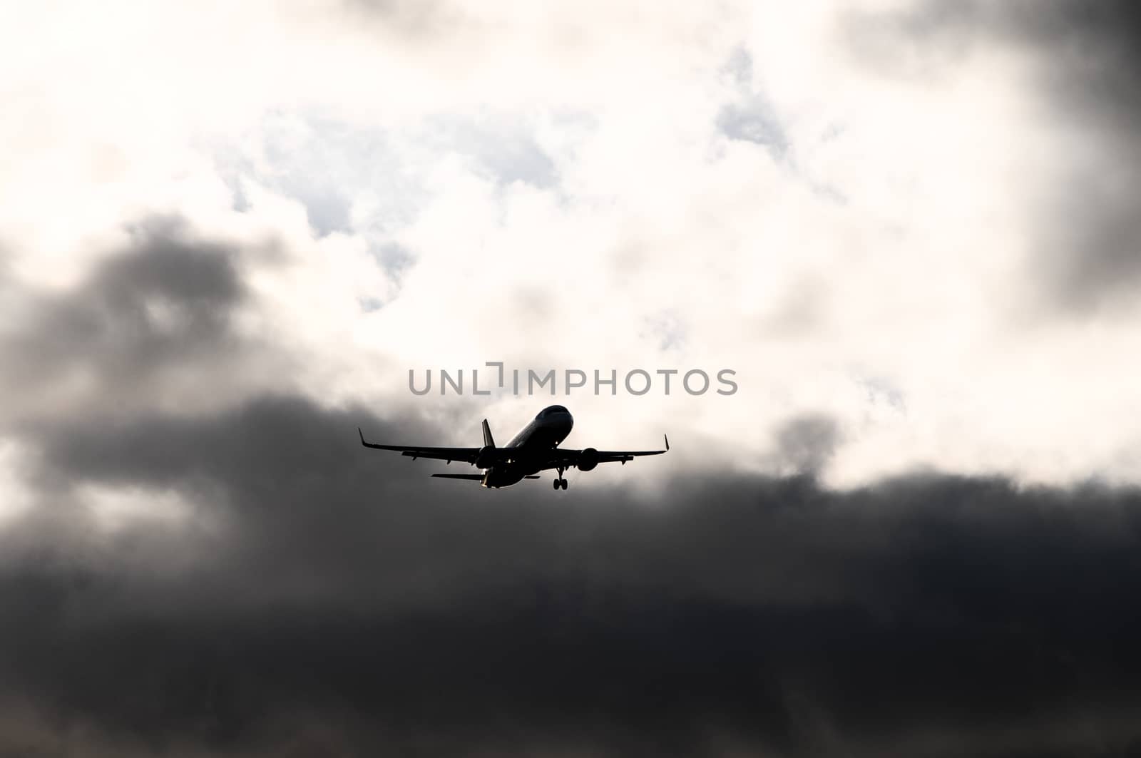 Silhouette of an Airplane Landing over a evening sky