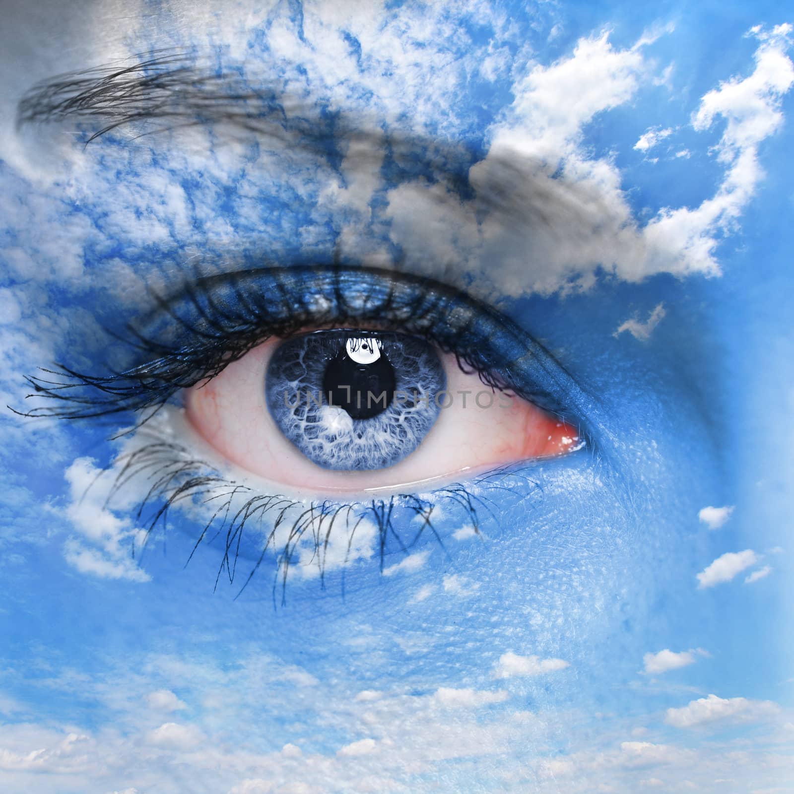 Blue human eye and cloudy sky on face