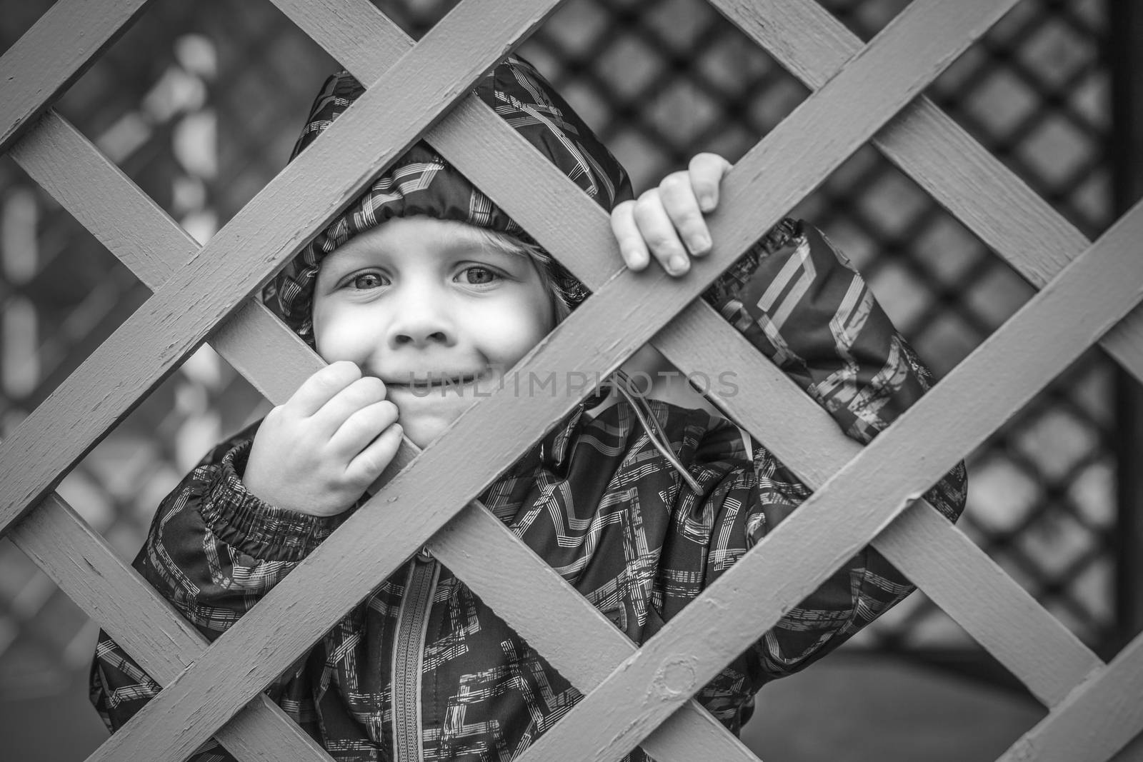 Cute little baby boy  looking through fence