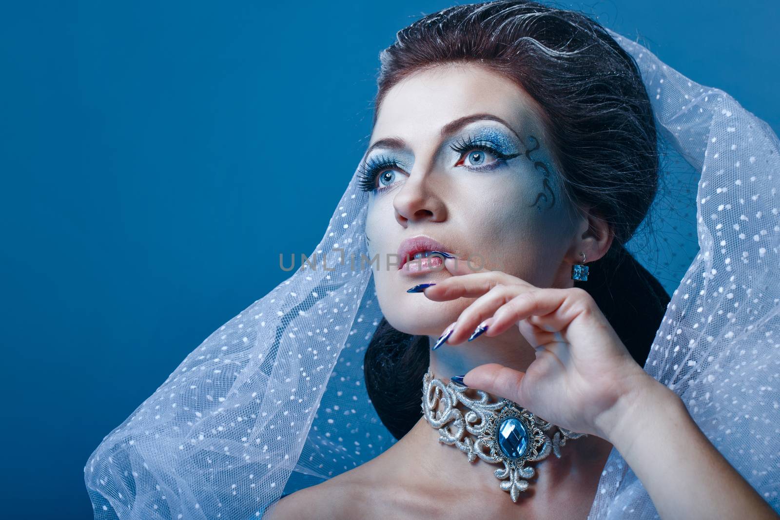 Young girl with a theatrical make-up as a fairy snow queen