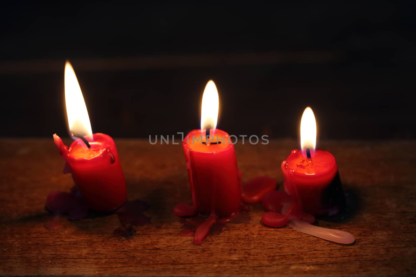 Three glowing candles close up, shallow dof 