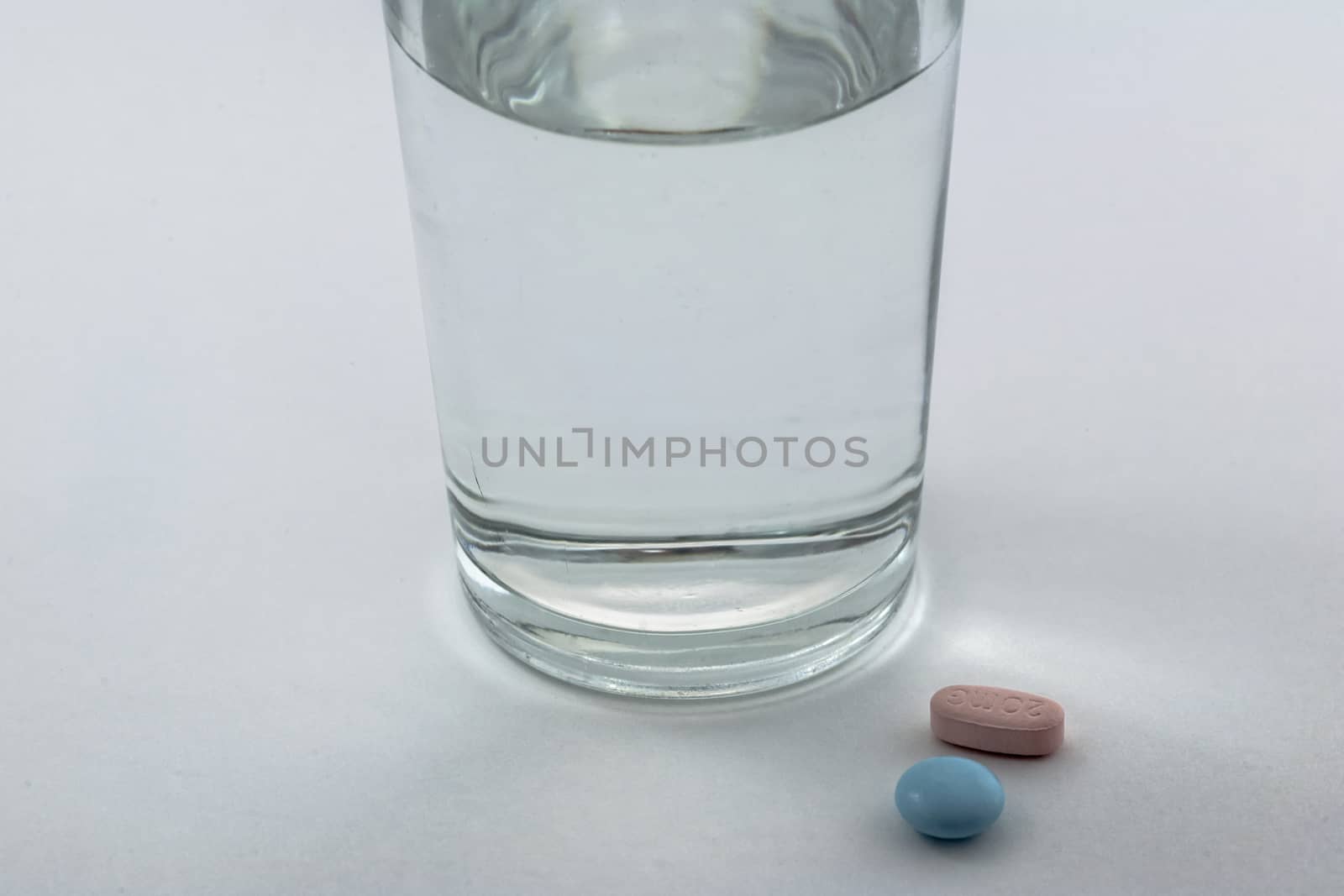 Glass of water and pills isolated on white background by digicomphoto