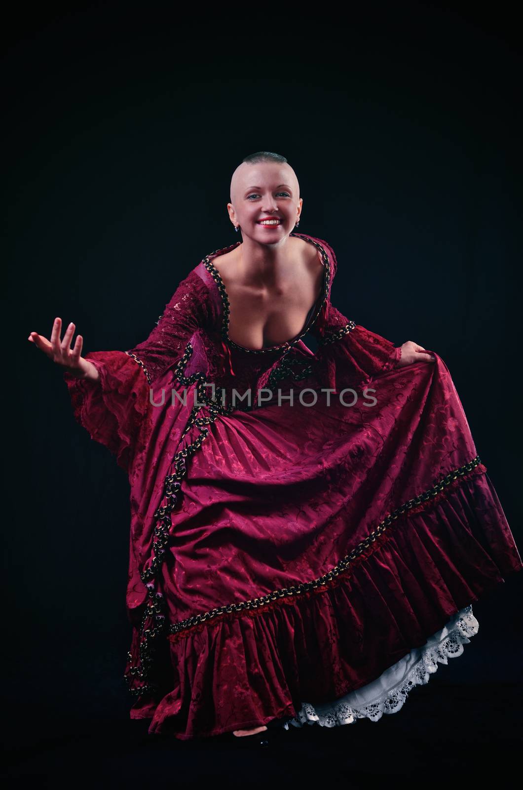 Bald girl in baroque costume on black background
