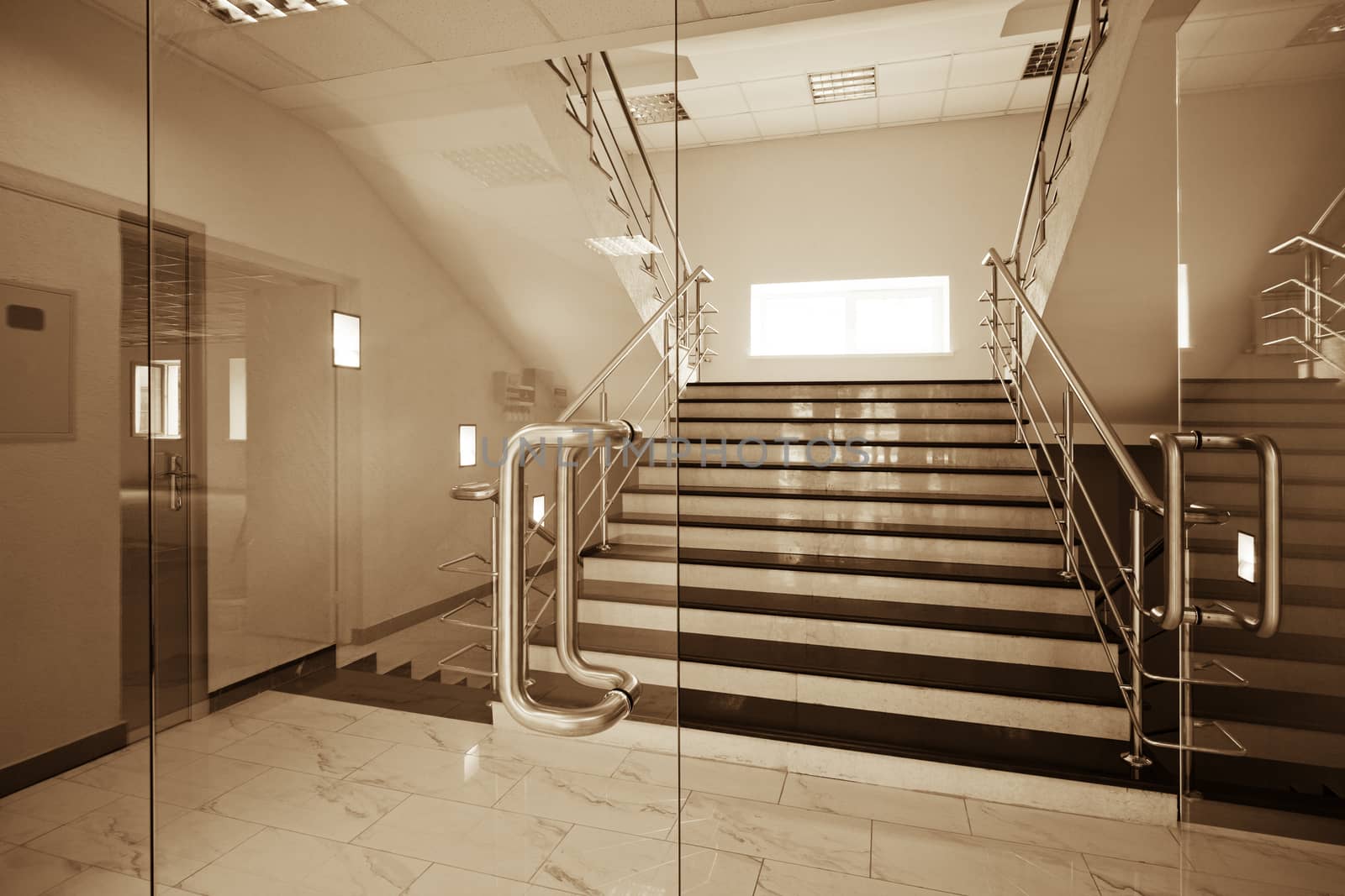 Glass doors with a kind on a marble staircase