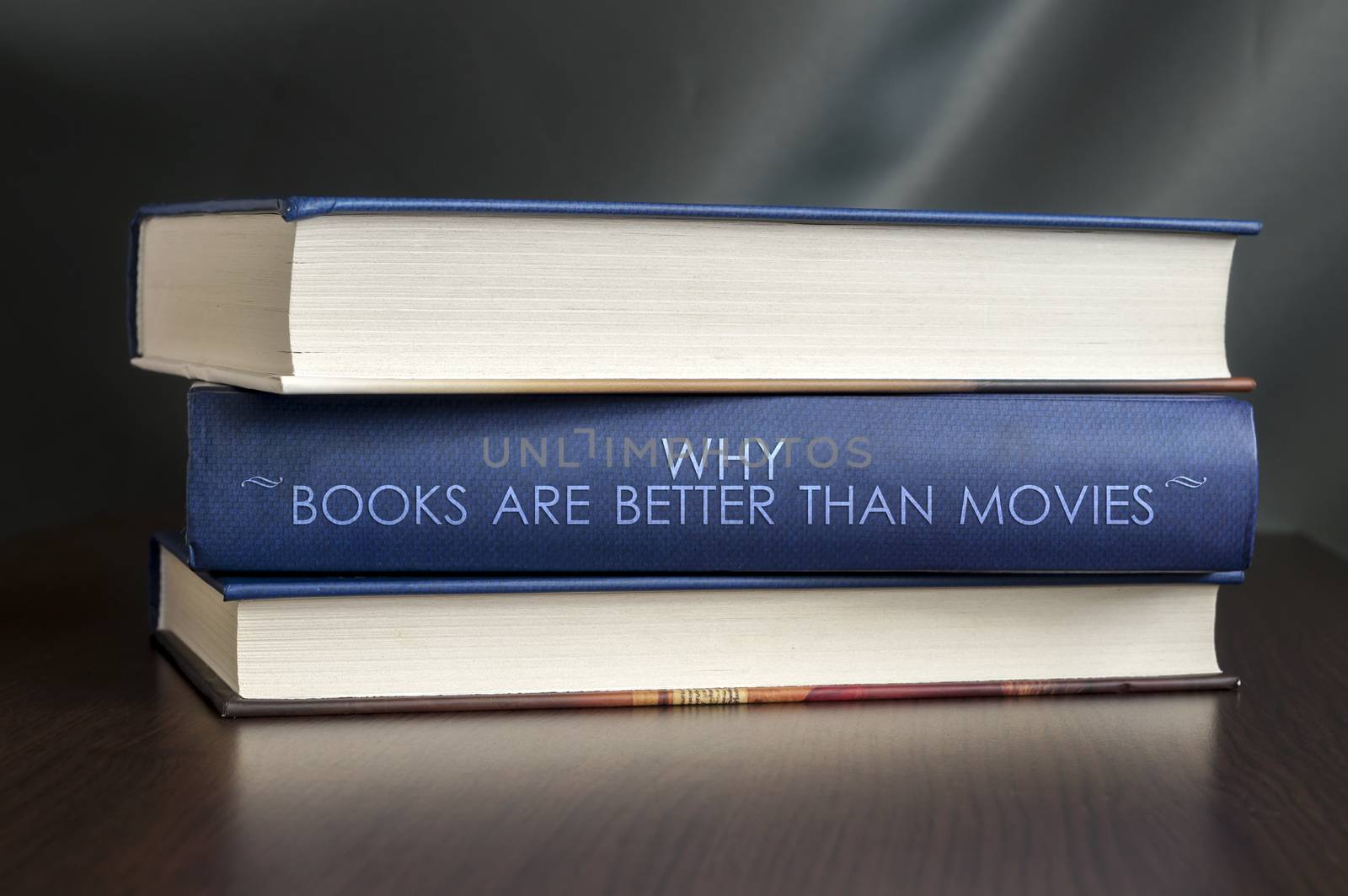 Books on a table and one with " Why books are better than movies " cover. Book concept.
