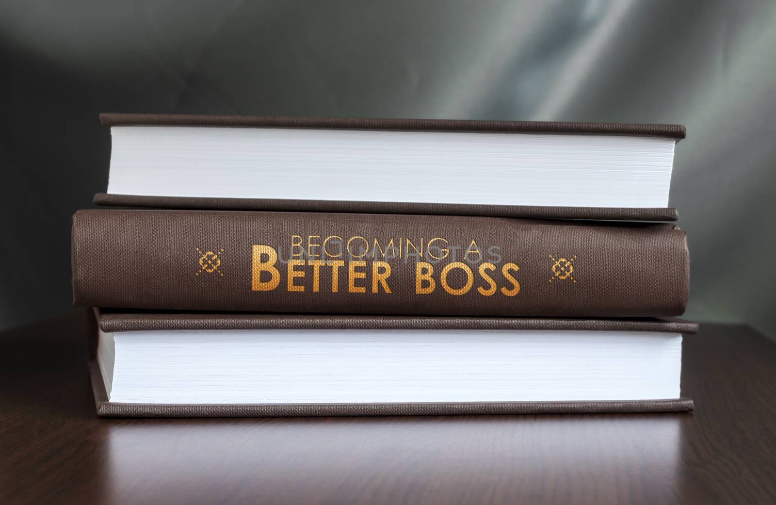 Books on a table and one with " Becoming a better boss. " cover. Book concept.