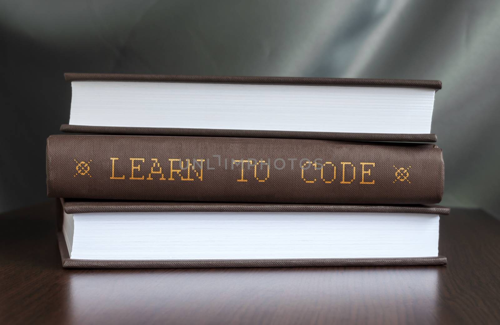 Books on a table and one with " Learn to code. " cover. Book concept.