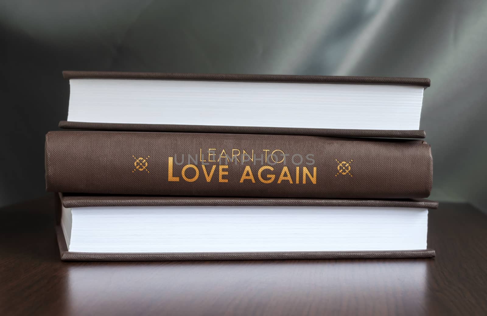 Books on a table and one with " Learn to love again. " cover. Book concept.