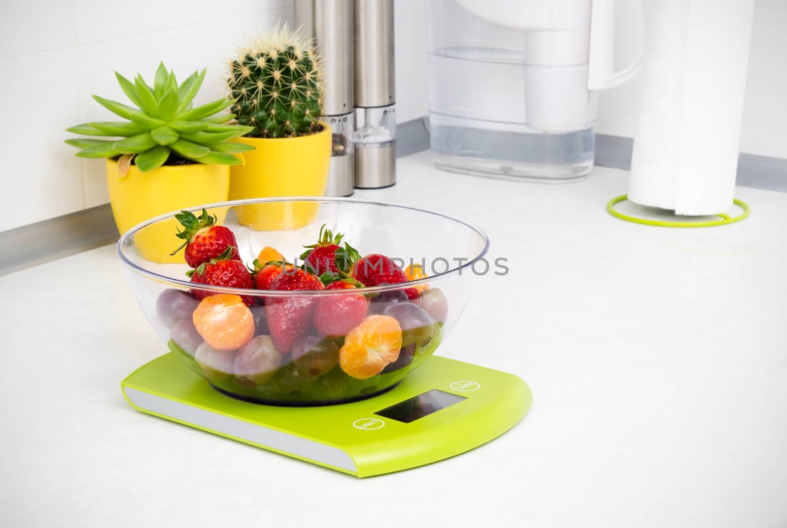 Lots of fruit on the kitchen scale in a modern kitchen by simpson33