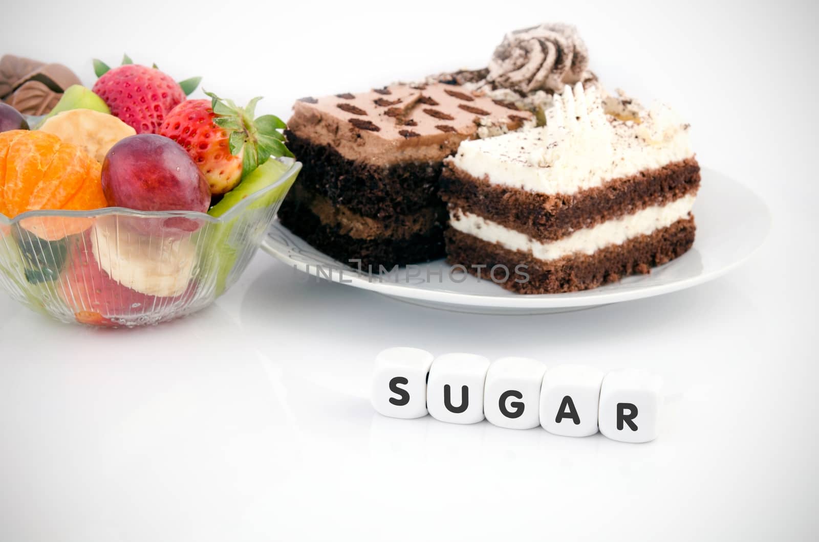 Sugar word on dices. Cake and fruits in babkground