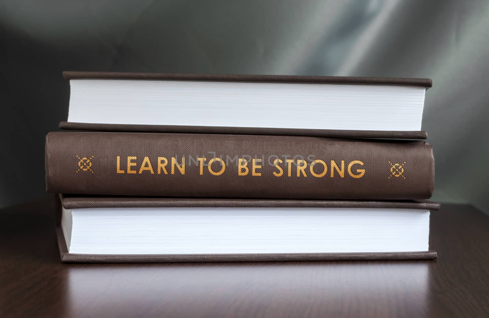 Books on a table and one with " Learn to be strong. " cover. Book concept.