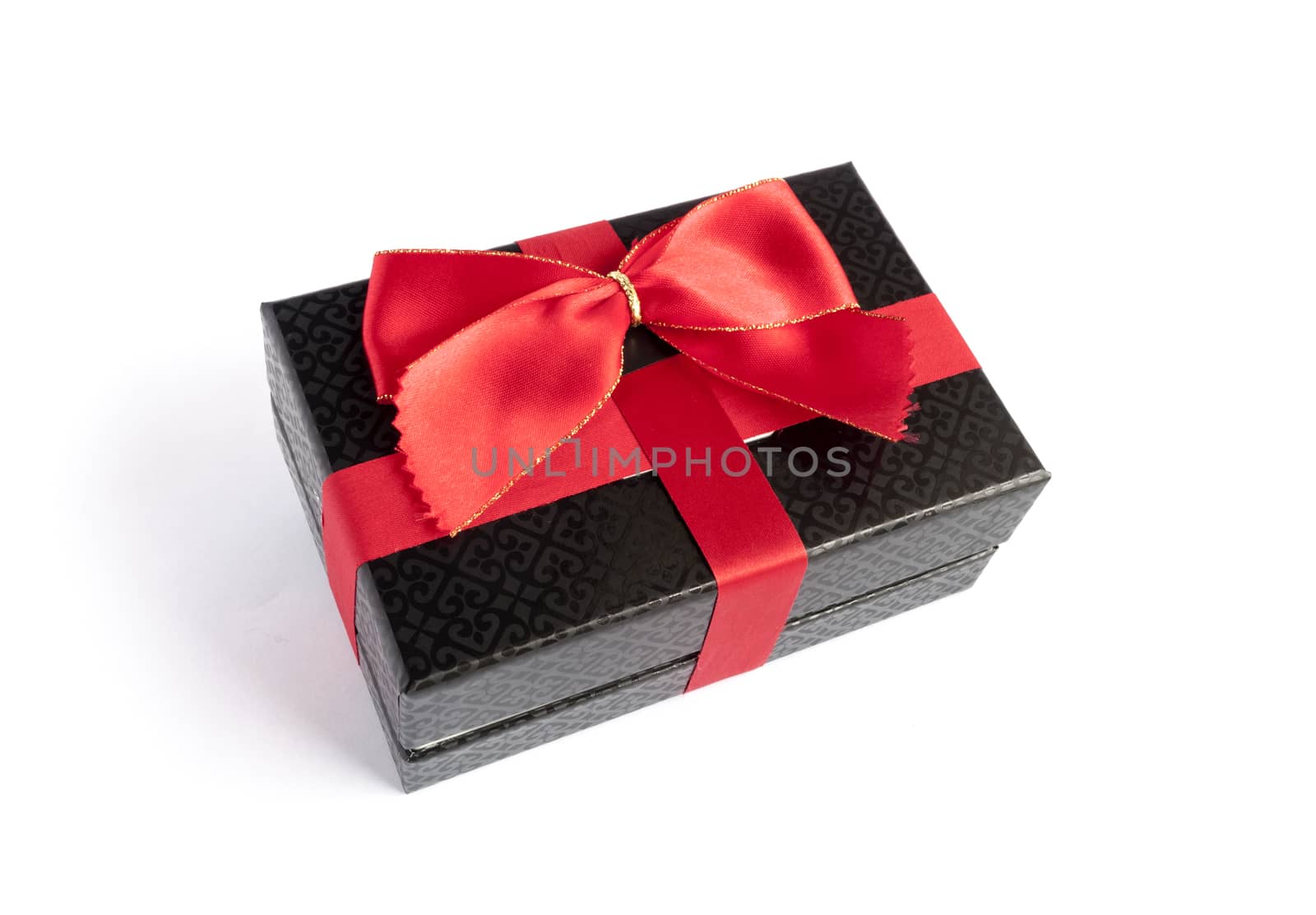 Single black gift box with red ribbon on white background.