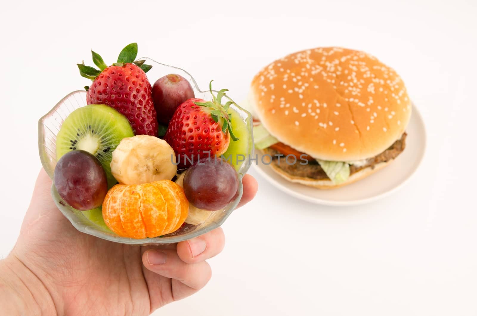 Choosing between hamburger and fruits. Food on white background by simpson33
