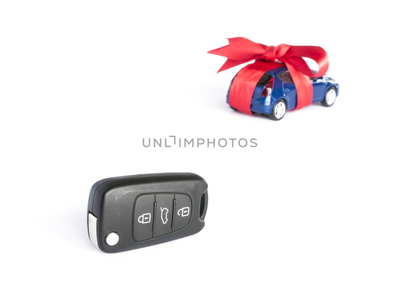 Gift car concept with red Bow and car key on focus