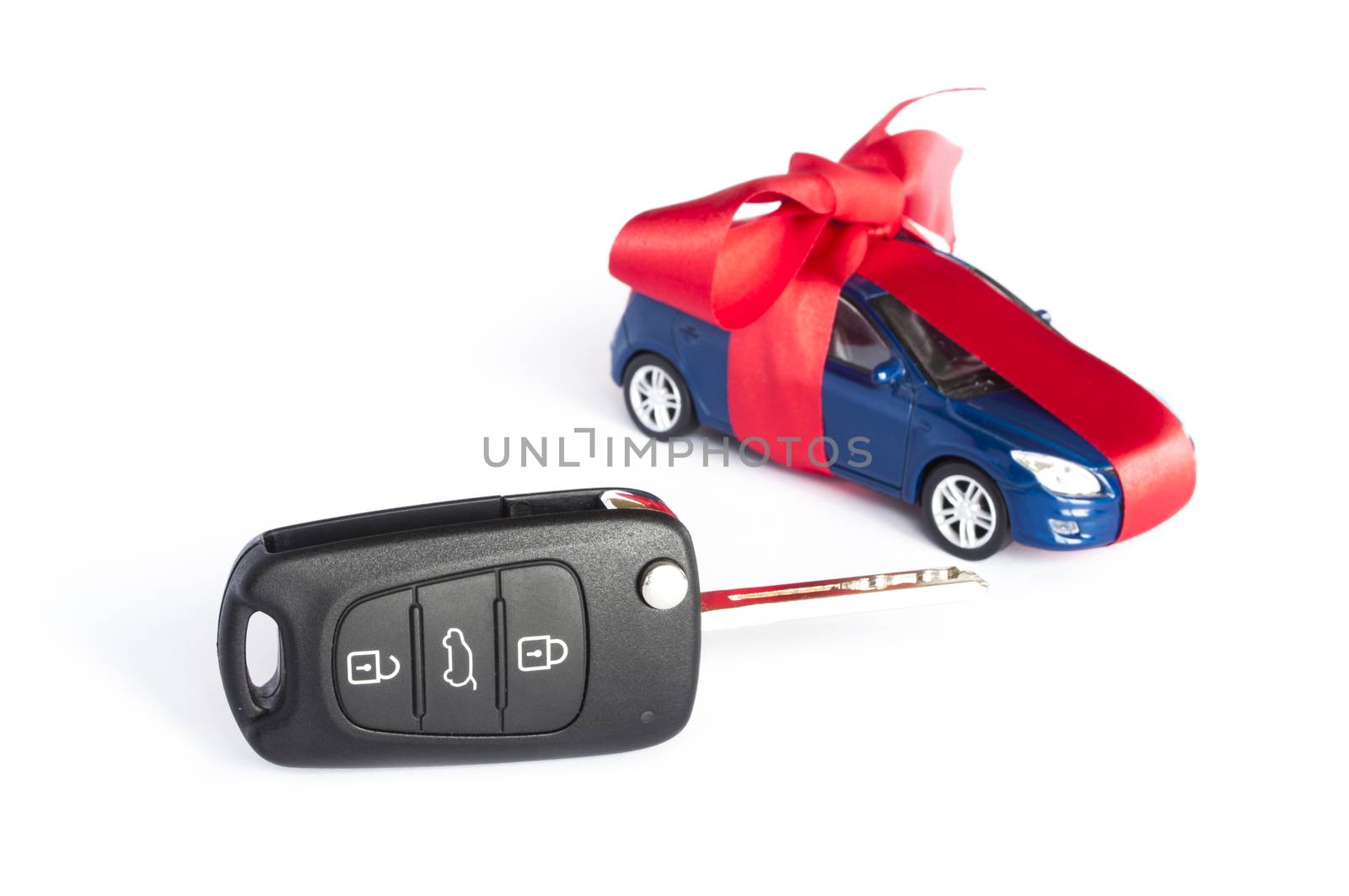 Gift car concept with red Bow and car key on focus