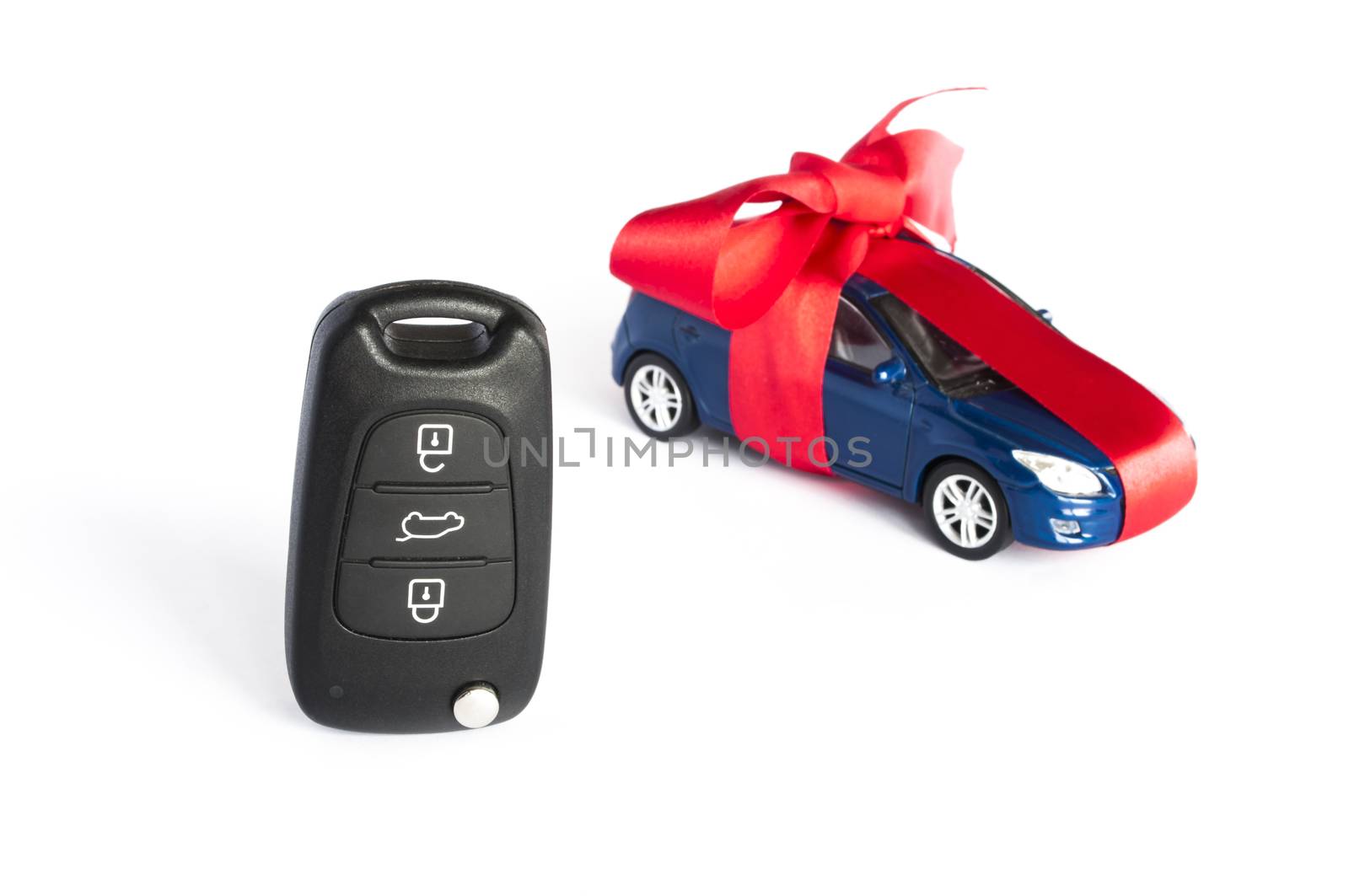 Gift car concept with red Bow and car key on focus
