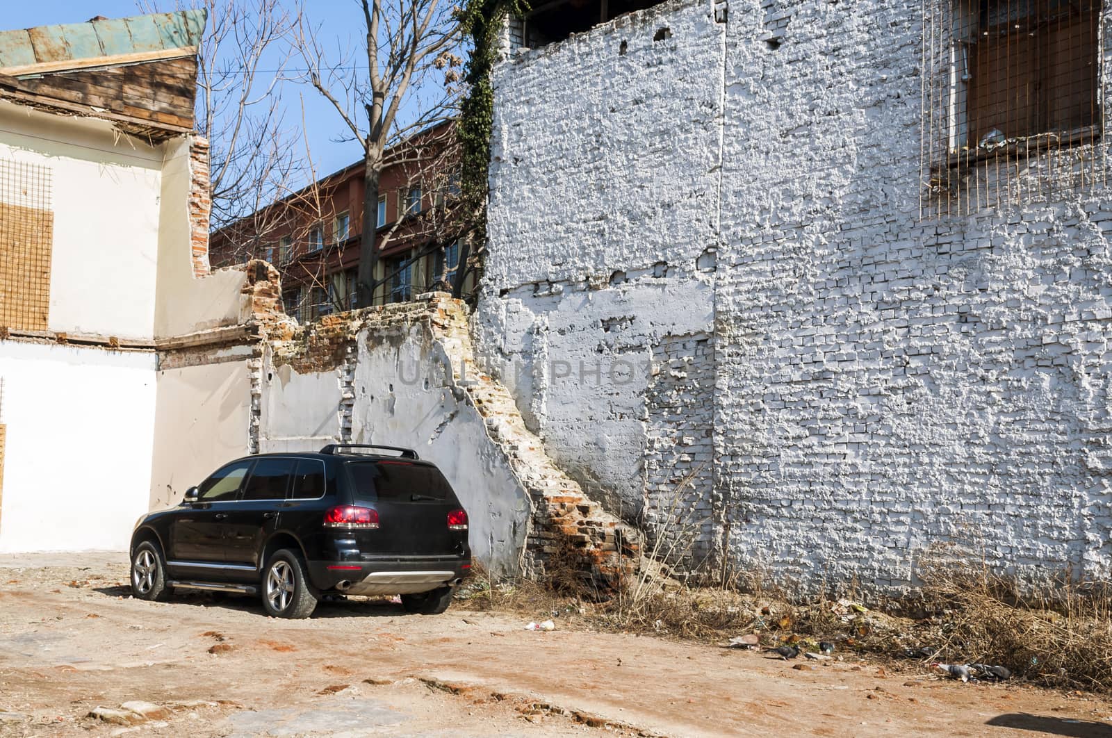 Black car on a abandonated white house