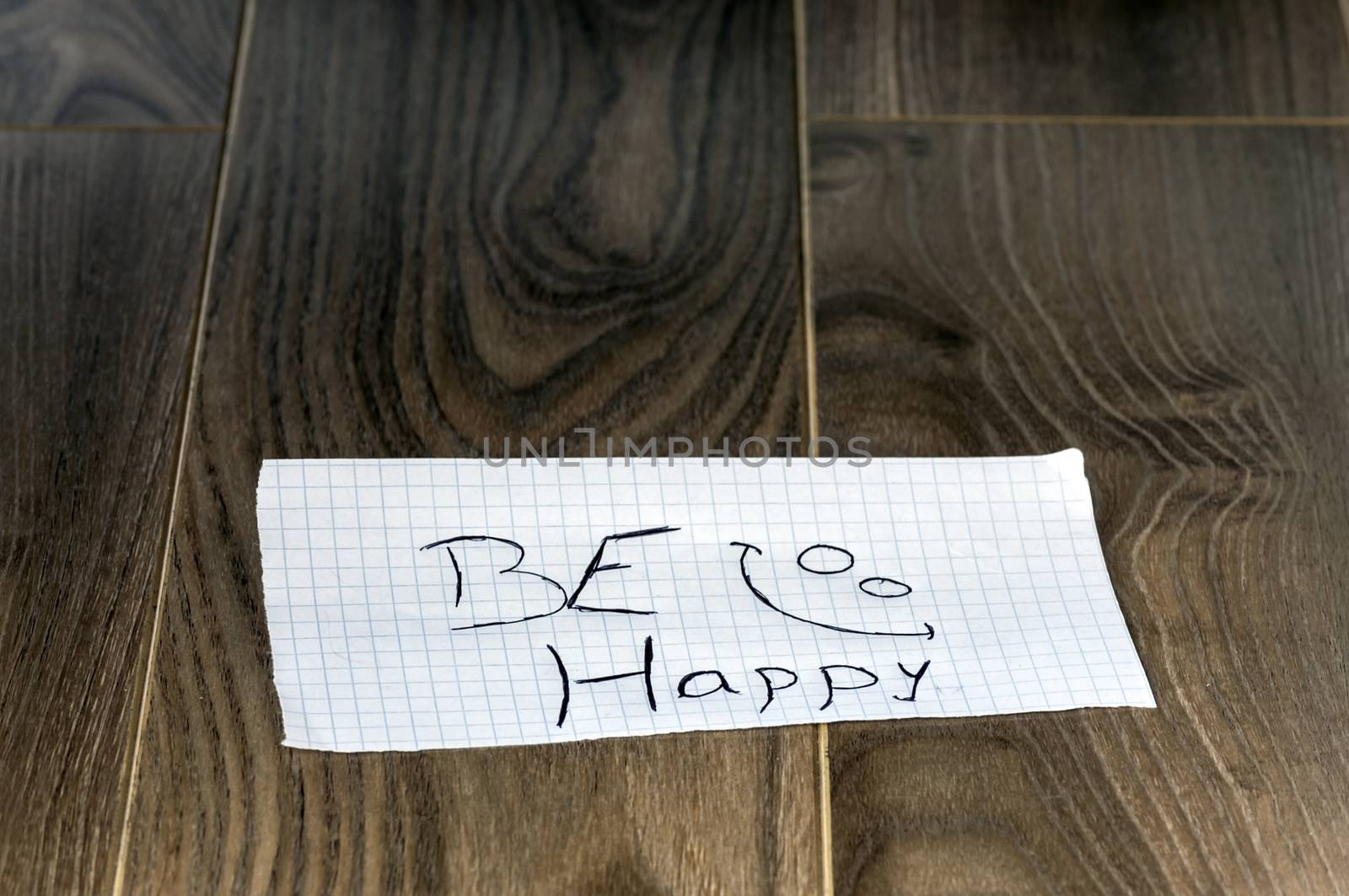 Be happy - Kid writing with a smile face on wood background