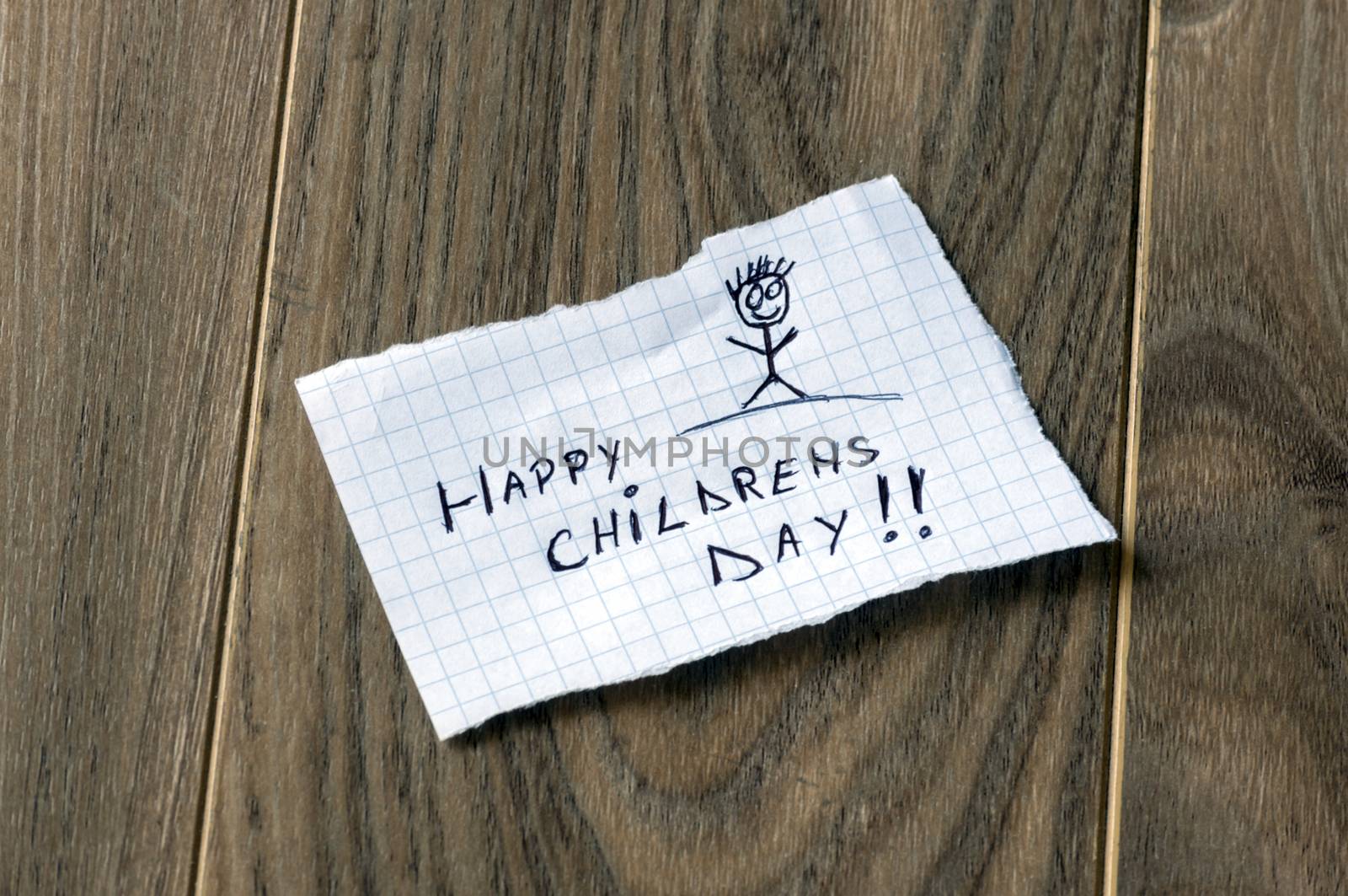 Happy Childrens Day - Kid writing with a smile man on wood background