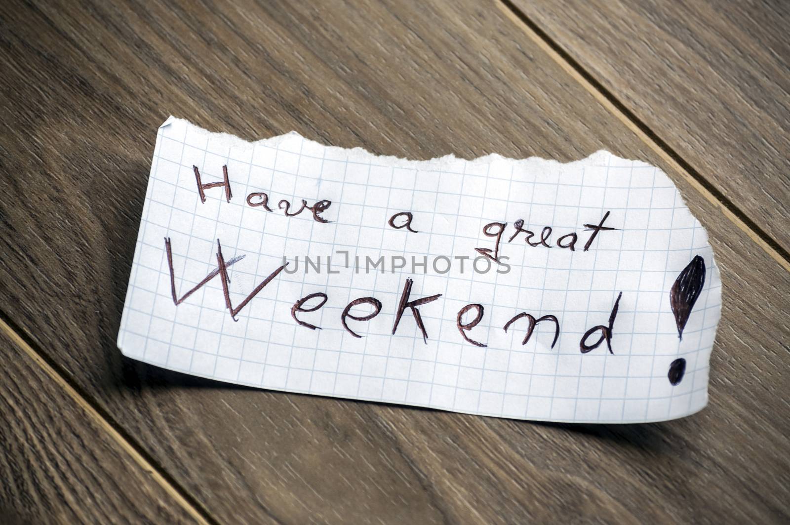 Have a great Weekend - Hand writing text on a piece of paper on wood background