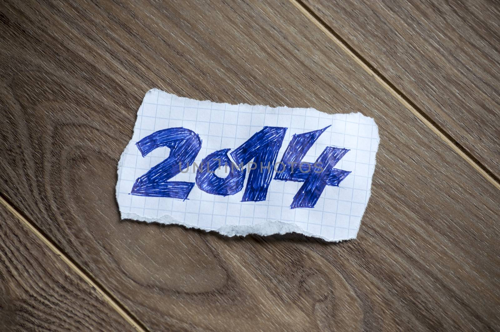 New Year written on piece of paper, on a wood background.