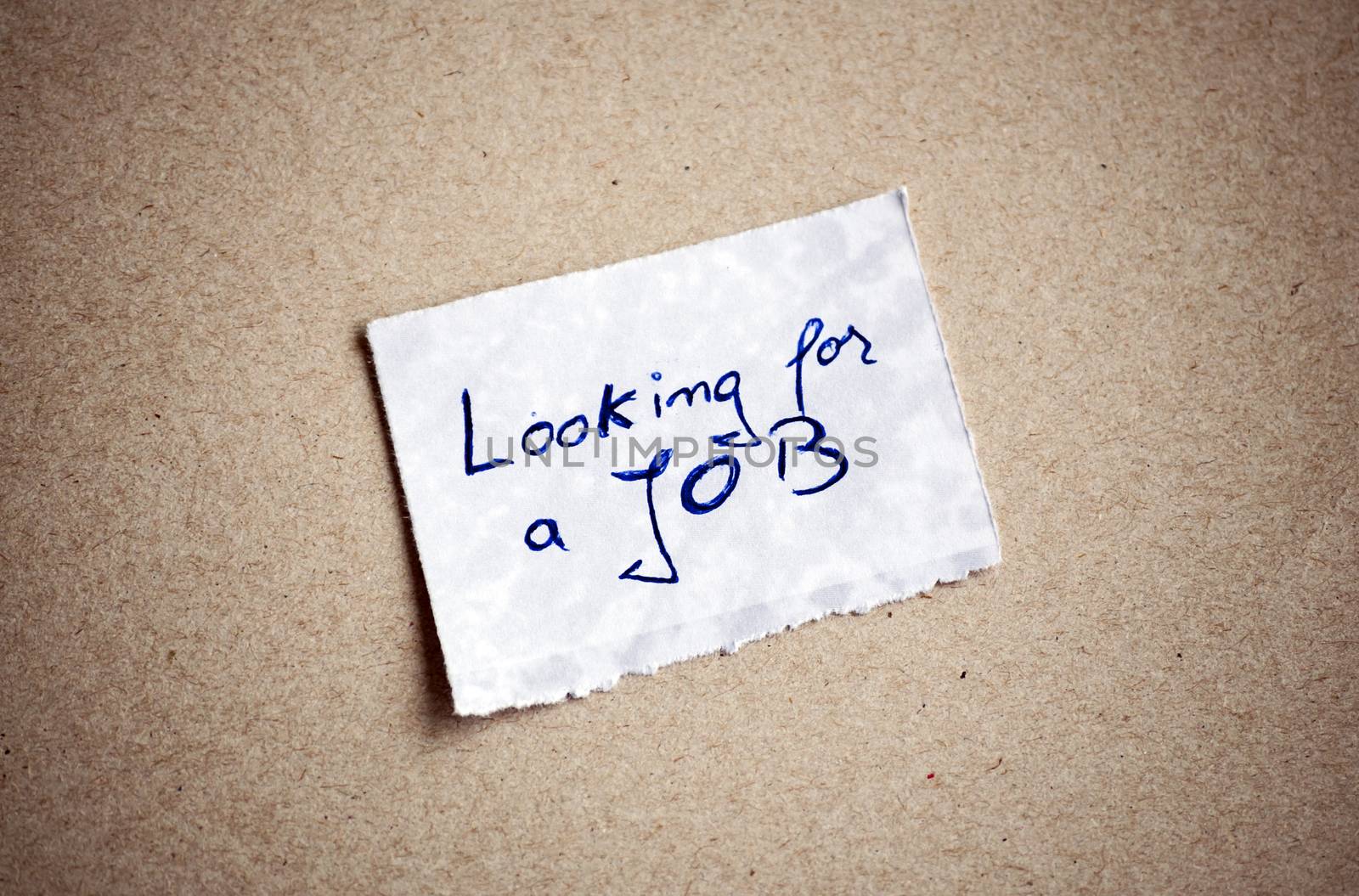 Looking for a Job message,written on piece of paper, on cardboard background. Space for your text.