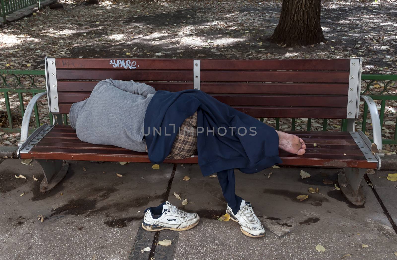 Bucharest, Romania- July 01: Sleeping homeless man on the bench in a public park on July 01, 2013 in Bucharest, Romania. In Bucharest has almost 5000 homeless mans in 2012.