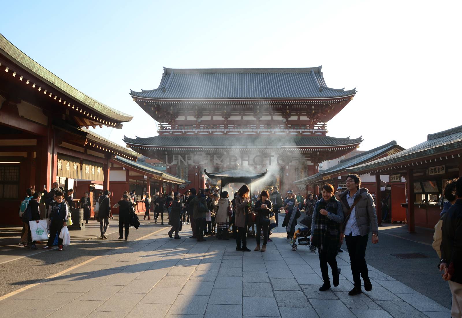 TOKYO, JAPAN - NOV 21: Buddhists gather around a fire to light incense and pray at sensoji temple by siraanamwong