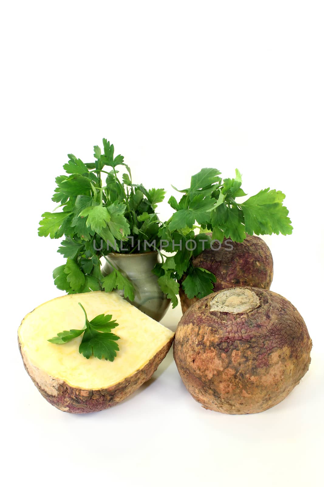 two turnips and parsley against white background