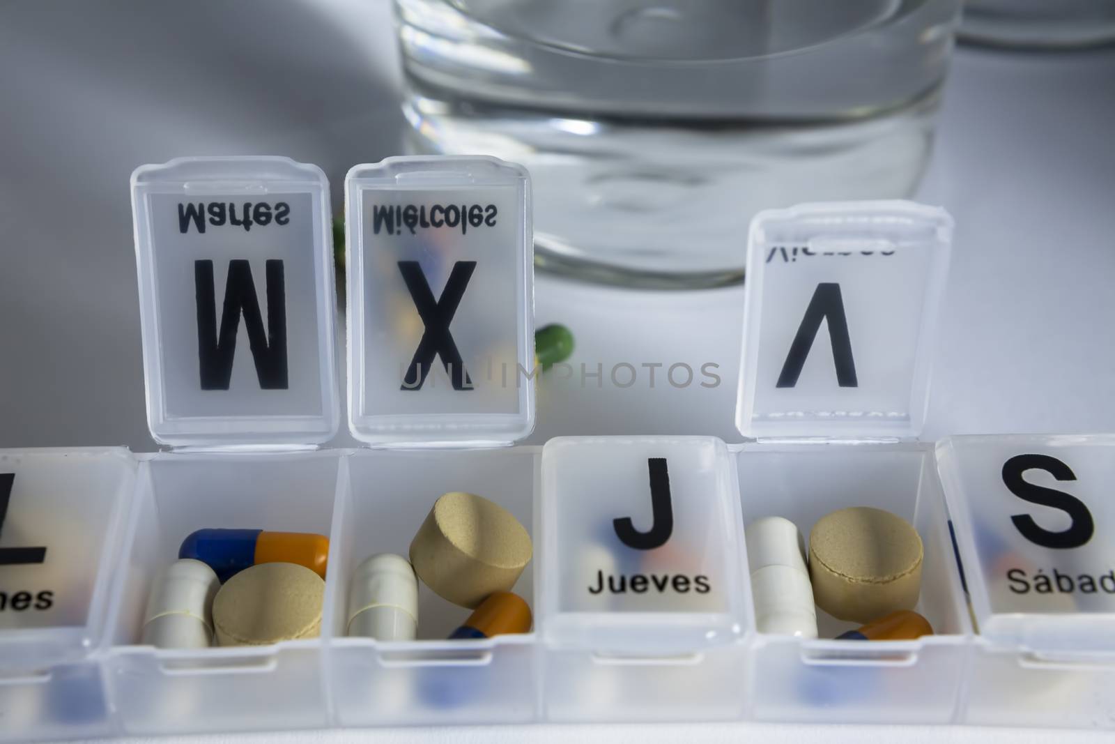 Pills with pill organizer, writing in Spanish