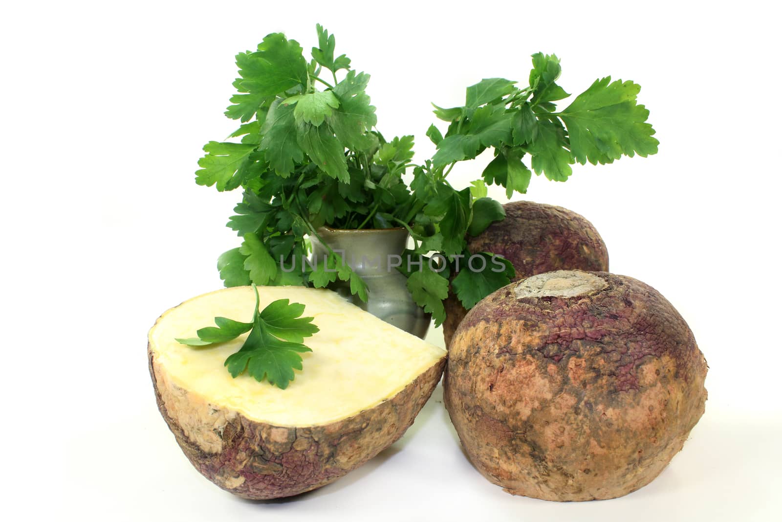 two turnips and parsley against white background