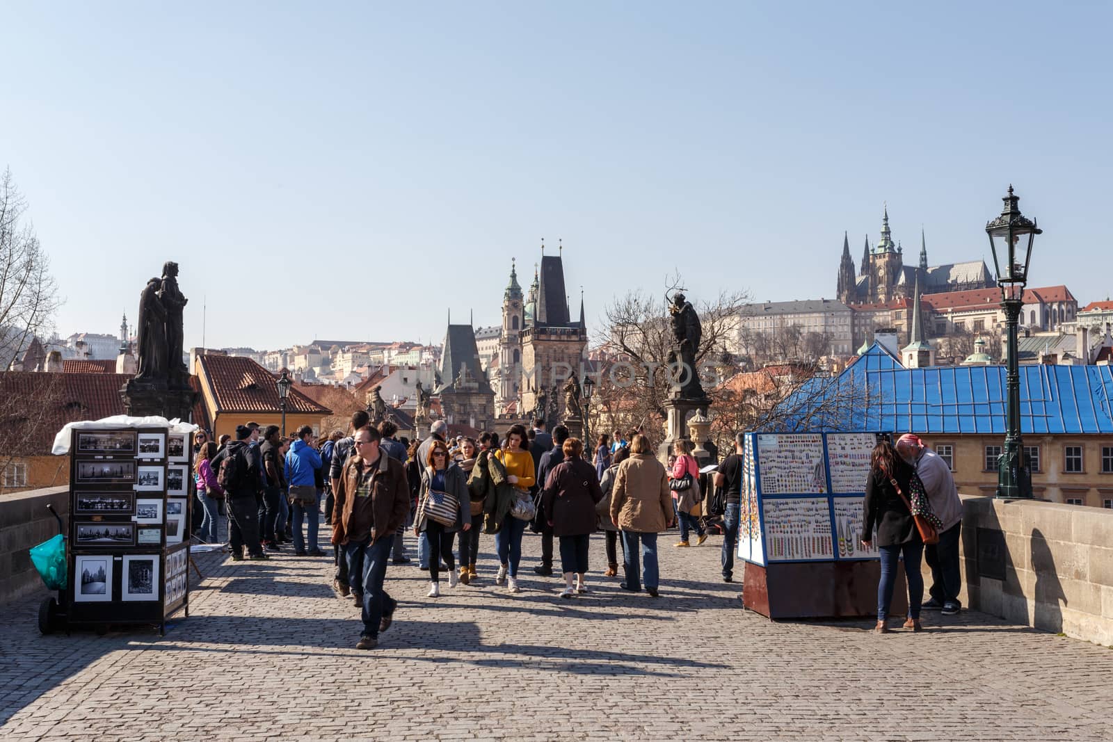 PRAGUE, CZECH REPUBLIC - MARCH 13: Charles Bridge on march 13, 2014 in Prague Czech Republic. Charles Bridge is a popular tourist attraction in Prague. On the bridge you can find many street artists.