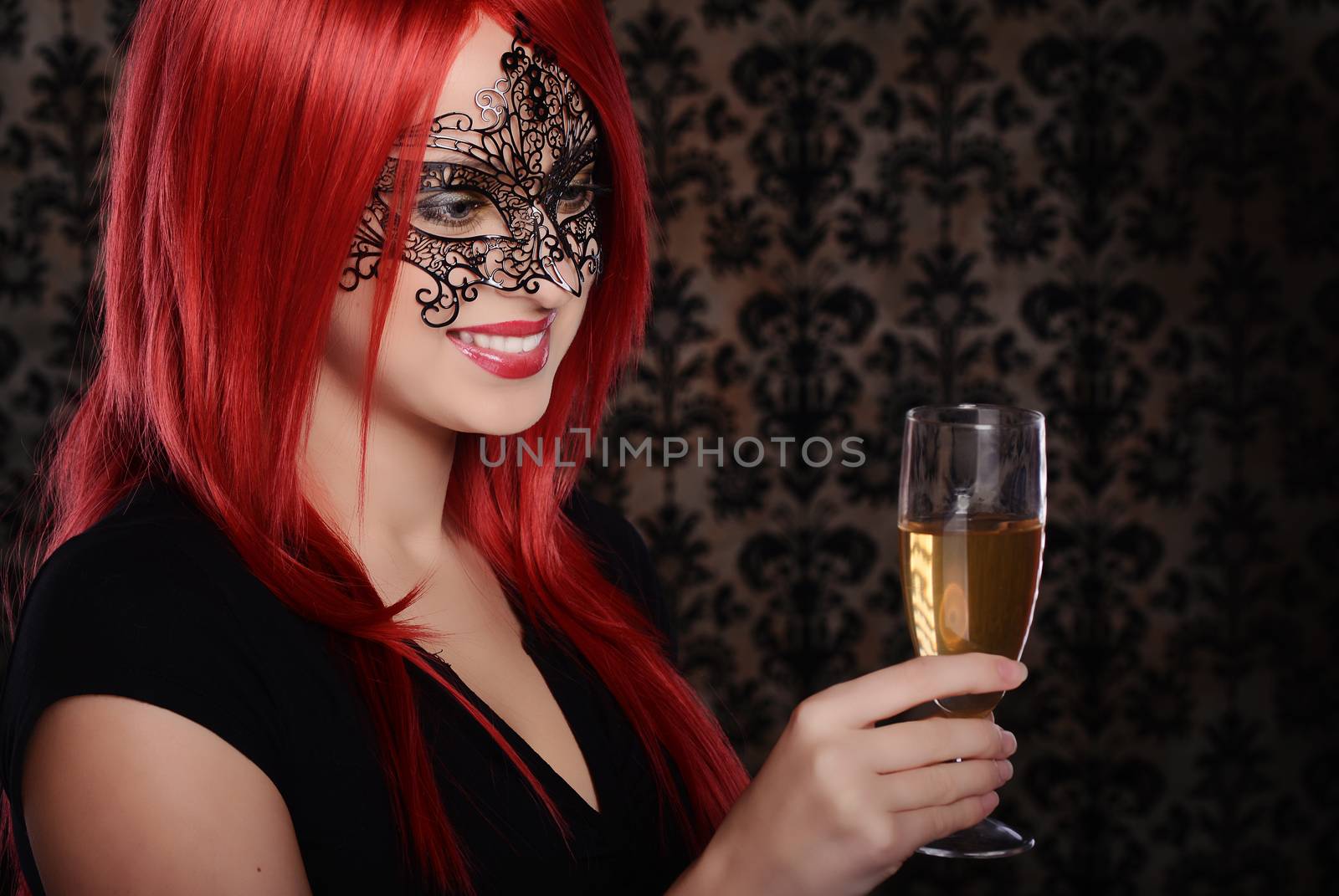Beautiful caucasian red haired woman in carnival mask over blue background