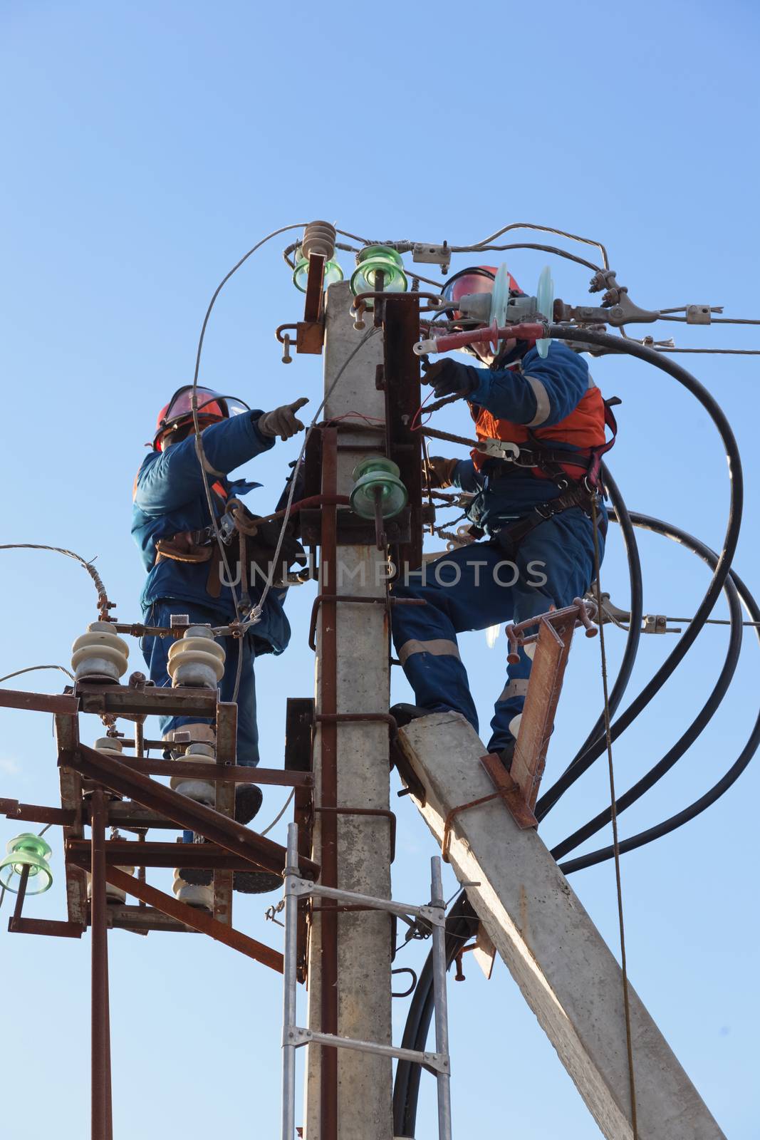 Electricians working at height  by AleksandrN