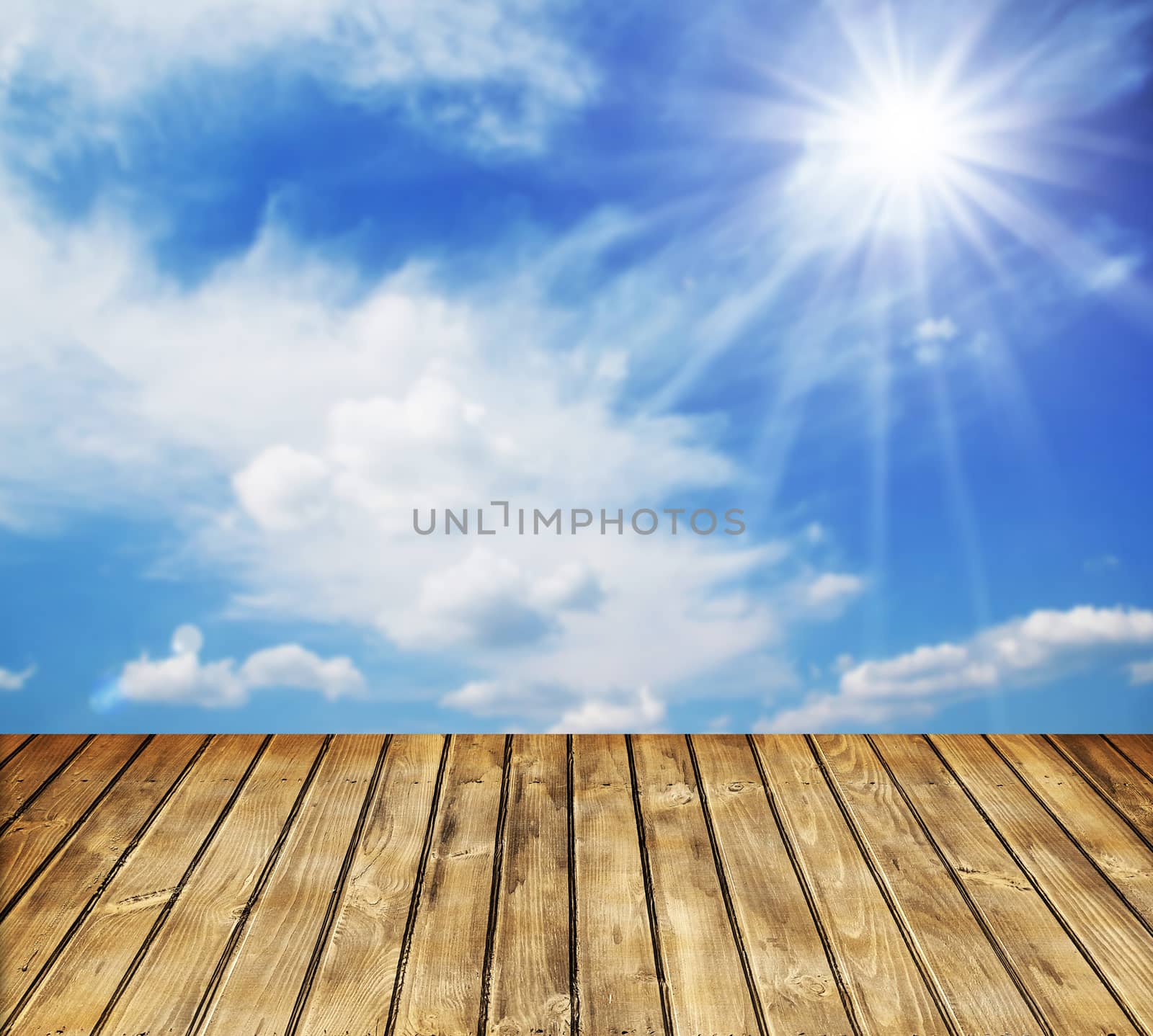 Empty wooden table and blue cloudy sky in background