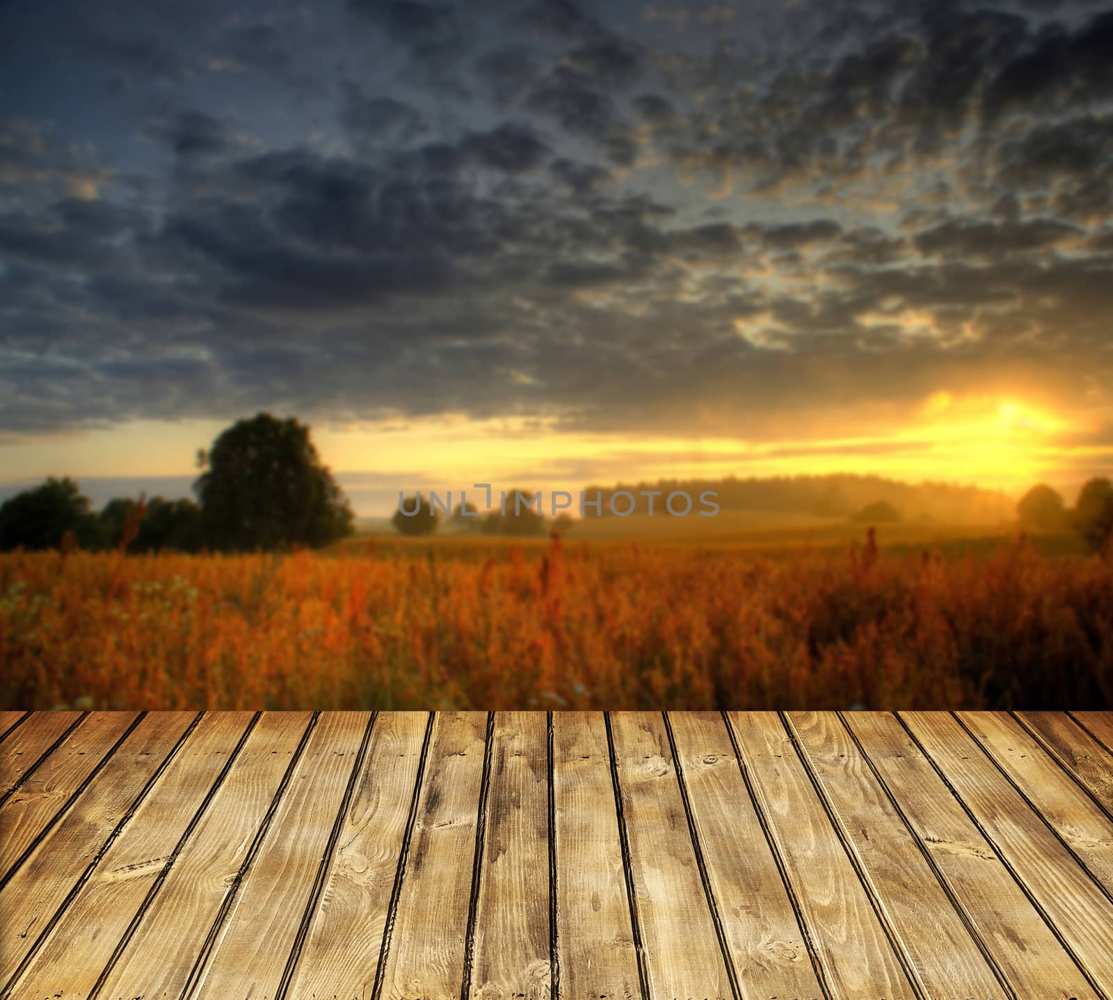 Empty wooden table and blue summer sunset in background