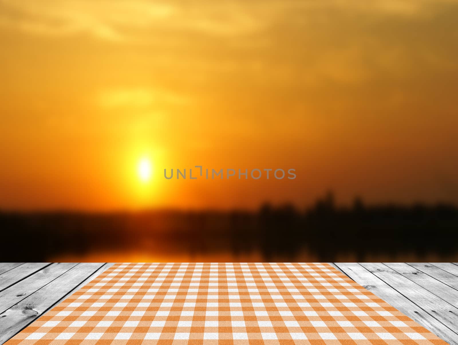 Empty wooden table and sunset sky in background