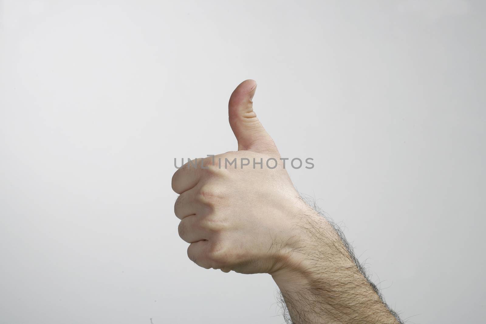 Hand with thumb up isolated on white background. Ok sign by man 