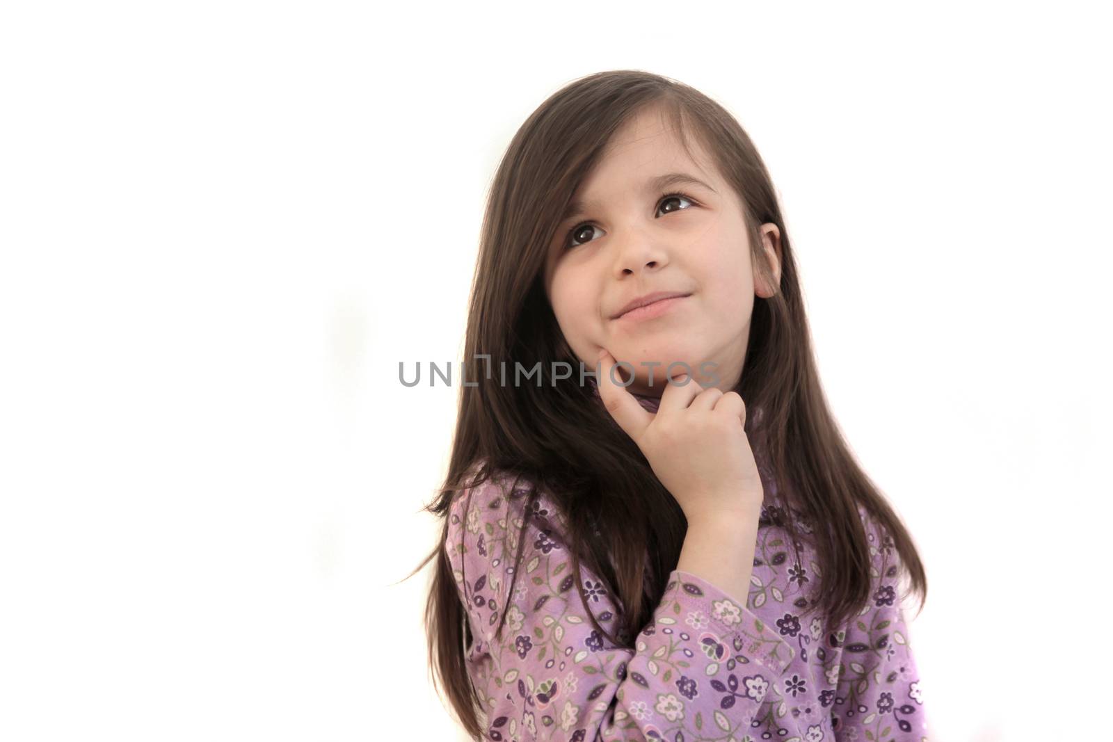 Pretty little brunette 6 year old girl thinking, looking up with finger to face on a white background and copyspace