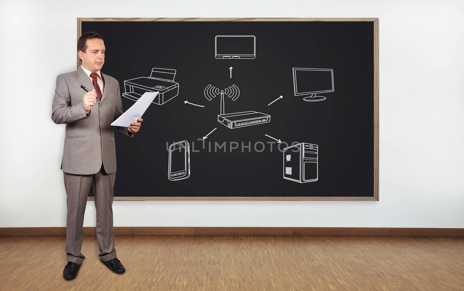 businessman standing in office and blackboard with computer network