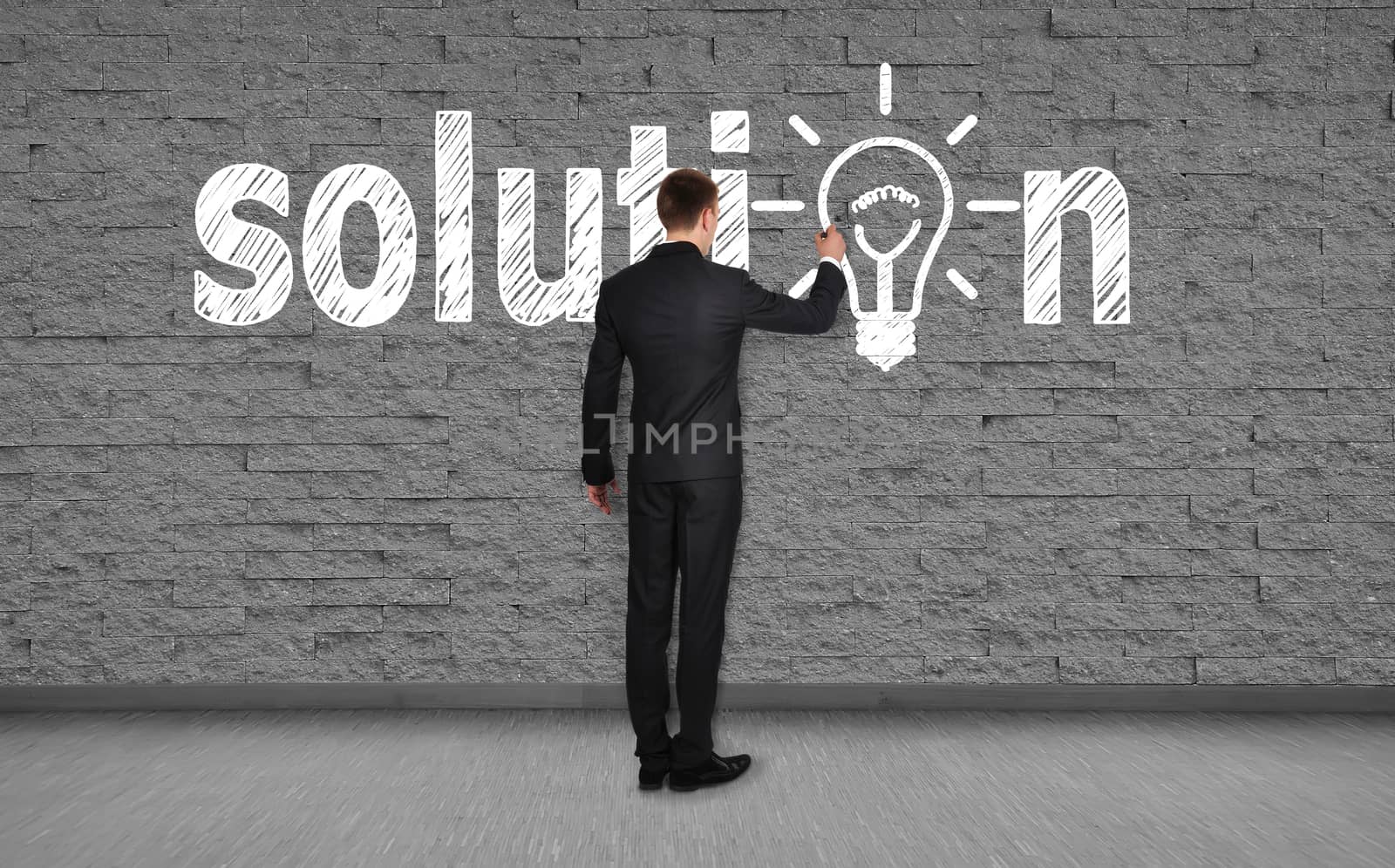 businessman drawing solution on brick wall